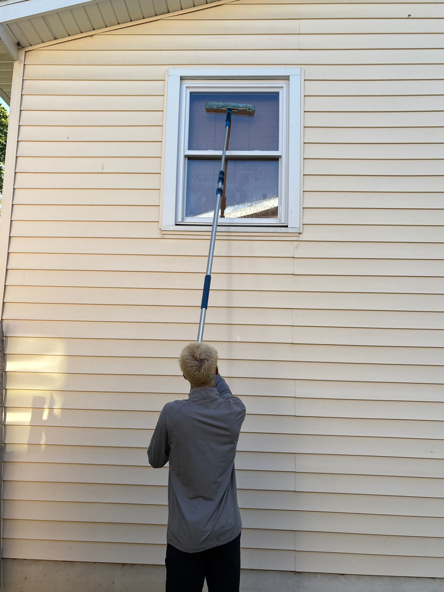 Window cleaner using an extension pole to reach a high window