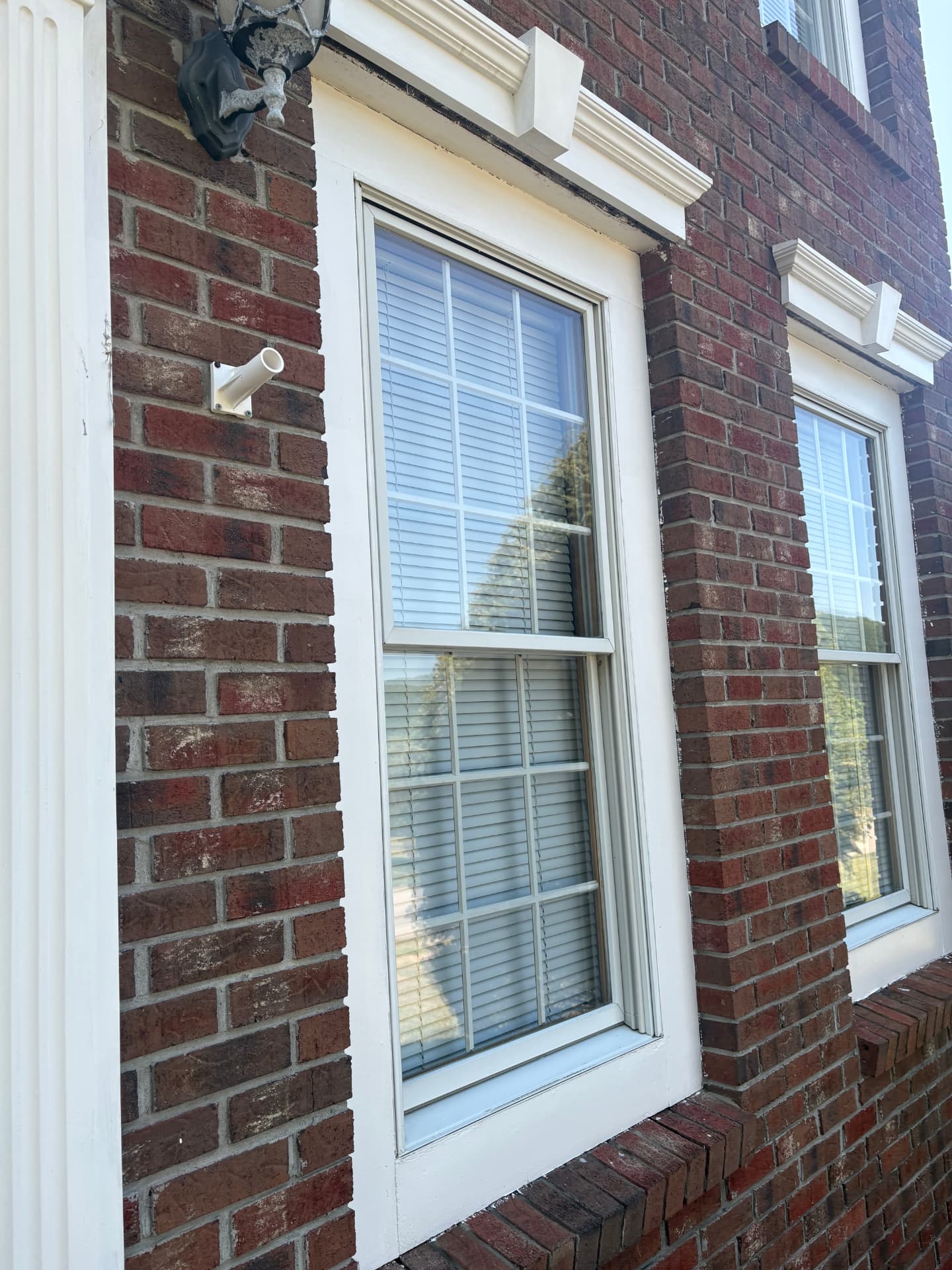 Clean windows and trim on a brick house exterior